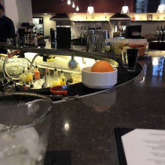 Bar tender talking, glasses with ice cubes on bar, bar machines