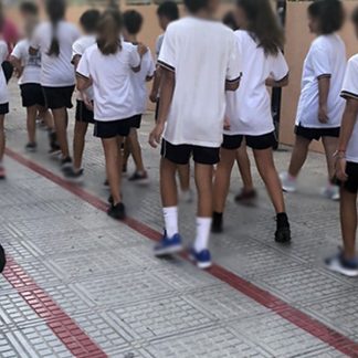 School, pupils, pre-teens, walking by, talking, laughing, squealing, younger children playing in background, distant traffic, Ibiza, Spain
